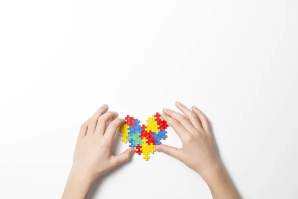 Kinderhände mit bunten Herzen auf weißem Hintergrund. Konzept zum Welt-Autismus-Tag — Stockfoto