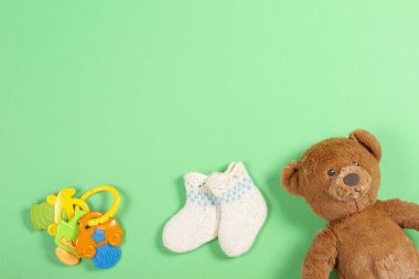Arka plan çocuklar. Beyaz yün Bebek çorap ve oyuncak ayı ve oyuncak yeşil zemin üzerine