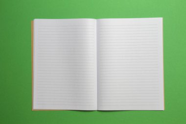 Boş yeşil zemin üzerine çizgili Not defteri açıldı. Üstten görünüm
