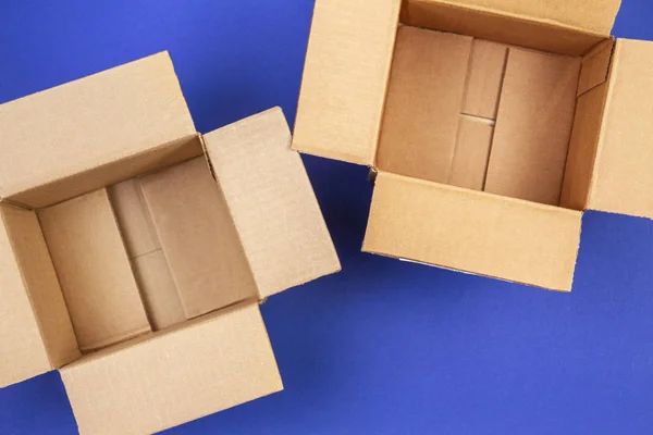 Дві порожні відкриті картонні коробки на синьому фоні — стокове фото