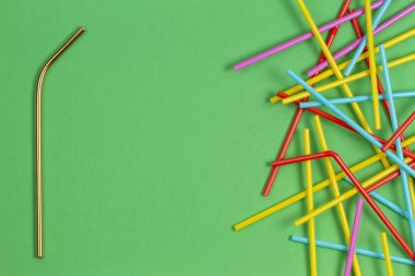 Yeşil arka plan üzerinde birçok çok renkli plastik çöp saman içme paslanmaz çelik yeniden kullanılabilir
