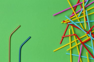 Yeşil arka plan üzerinde uçan kuştan çok çok renkli plastik çöp ile içme iki paslanmaz çelik yeniden kullanılabilir. Hiçbir plastik, sıfır atık kavramı