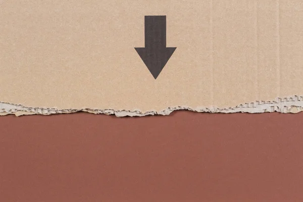 Браун гофрованого картону нерівні краю з чорну стрілку на фоні коричневий — стокове фото