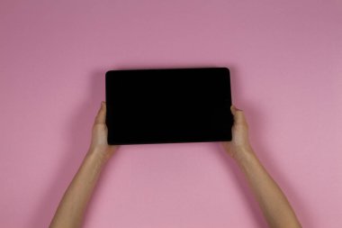 Tablet bilgisayarda pembe bir arka plan ile çocuk el