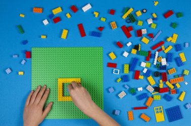 Vilnius, Litvanya - 23 Şubat 2019. Çocukların elleri masada renkli lego bloklarıyla oynar.