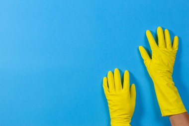 Mavi arka plan sarı eldivenlerini elinde