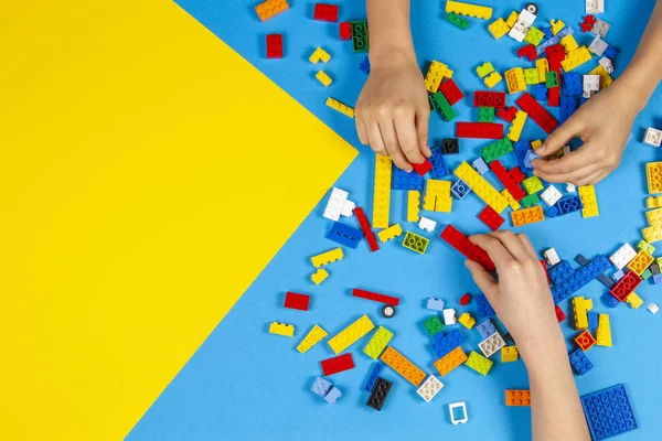 Vilnius, Lituânia - 23 de fevereiro de 2019. Crianças mãos brincam com blocos de lego coloridos na mesa — Fotografia de Stock