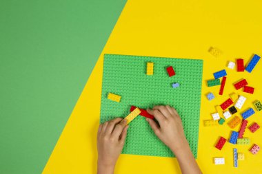 Vilnius, Litvanya - 23 Şubat 2019. Çocukların elleri masada renkli lego bloklarıyla oynar.