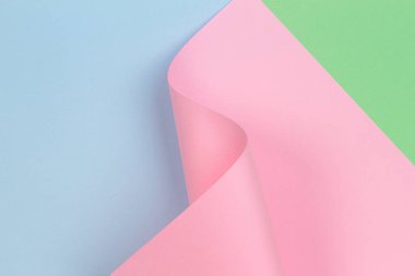 Mavi ve yeşil renkli kağıt üzerinde soyut geometrik pembe kağıt biçimi