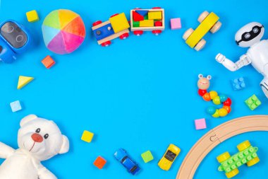Çocuklar oyuncak arka plan. Beyaz oyuncak ayı, ahşap tren, oyuncak araba, robot, açık mavi renkli renkli bloklar