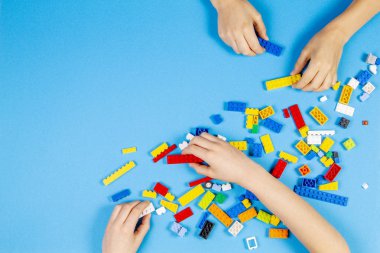 Vilnius, Litvanya - 23 Şubat 2019. Çocukların elleri masada renkli lego bloklarıyla oynar.