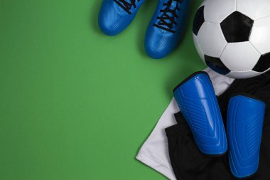 Futbol topu, mavi çizmeler, ayakkabısı, Beyaz tişört ve yeşil zemin üzerine siyah şort. Düz yatıyordu, en iyi görünümü