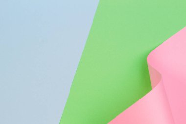 Mavi ve yeşil renkli kağıt üzerinde soyut geometrik pembe kağıt biçimi