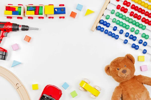 Crianças bebê brinquedos fundo com ursinho de pelúcia, ferramentas de brinquedo, trem de madeira, carros e blocos coloridos. Vista superior, flat lay — Fotografia de Stock