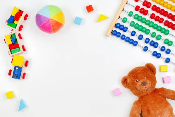 Crianças bebê brinquedos fundo com ursinho de pelúcia, trem de madeira, brinquedo ábaco e blocos coloridos. Vista superior, flat lay — Fotografia de Stock