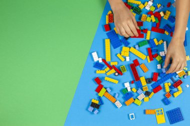 Vilnius, Litvanya - 23 Şubat 2019. Çocukların elleri masada renkli lego bloklarıyla oynar.
