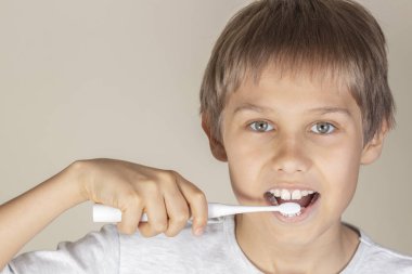 Beyaz elektrikli diş fırçası ile diş fırçalama çocuk