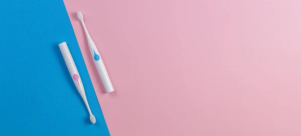 Two toothbrushes on blue and pink background. Top view — Stock Photo, Image