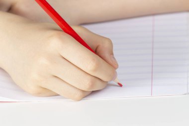 Çocuk el defteriboş sayfaya karşı kırmızı kalem tutan