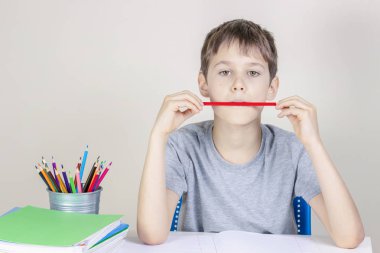 Çocuk masada ev ödevi yapıyor ve düşünme ya da hayal