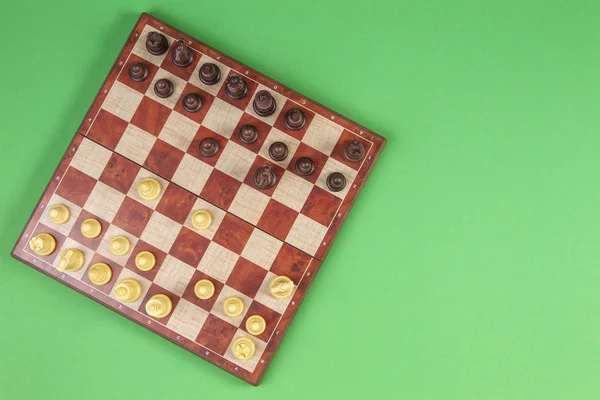 Chessboard with chesses on light green background, top view — Stock Photo, Image