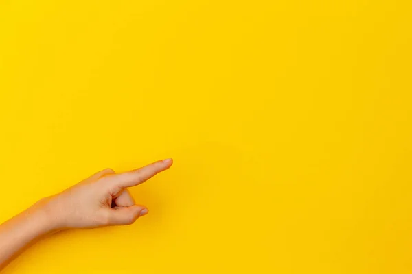 Manos de niño señalando algo sobre fondo amarillo — Foto de Stock