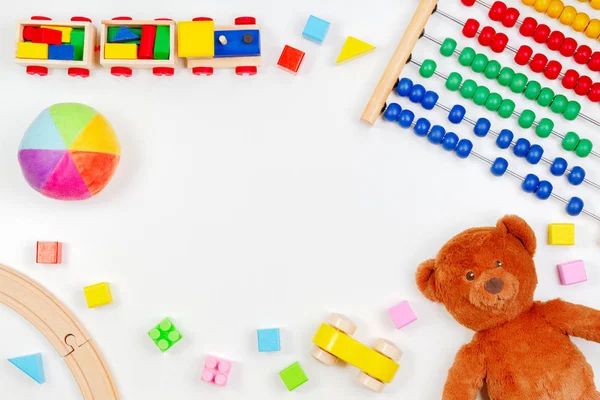 Crianças bebê brinquedos fundo com ursinho de pelúcia, ferramentas de brinquedo, trem de madeira, carros e blocos coloridos. Vista superior, flat lay — Fotografia de Stock