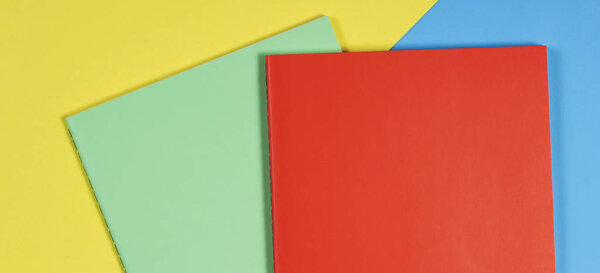 Красочные ноутбуки на синем и желтом фоне
