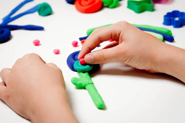 Manos de niño moldeado modelado de arcilla o plastilina sobre mesa blanca — Foto de Stock