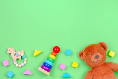 Oyuncak ayı ve yeşil arka plan üzerinde renkli bloklar ile Çocuk oyuncakarka plan çerçevesi