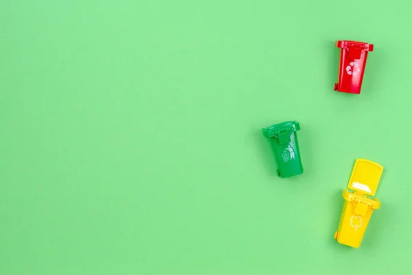 Recipiente colorido de contenedores de reciclaje con basura sobre fondo verde — Foto de Stock