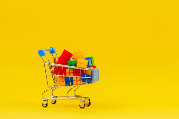 Panier plein de briques colorées sur fond jaune — Photo