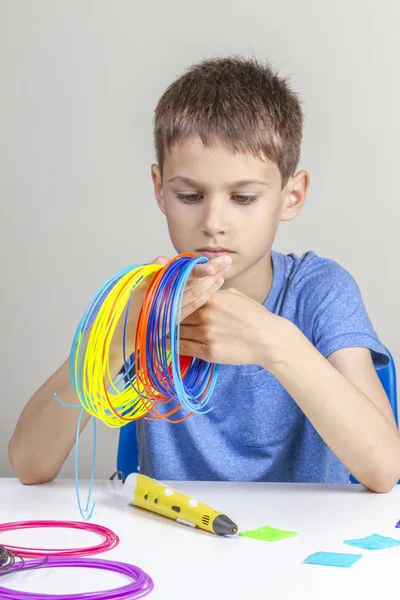 Criança segurando filamentos coloridos para caneta 3d e escolha a cor para o novo item — Fotografia de Stock