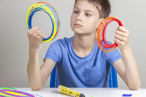 Criança segurando filamentos coloridos para caneta 3d e escolha a cor para o novo item — Fotografia de Stock