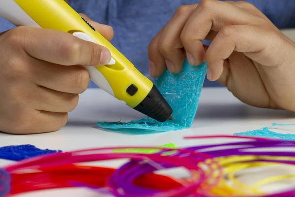 Mãos de criança com caneta de impressão 3d criando novo item — Fotografia de Stock