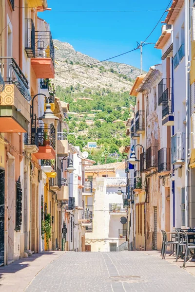Finestrat, İspanya - 12 Haziran 2019: Finestrat eski şehrinde güzel evler ve dağ arka planı ile dar sokak