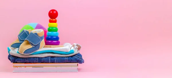 Adományozási koncepció. Gyerek játékok, könyvek és ruházat adományozás vagy jótékonysági a rózsaszín háttér — Stock Fotó