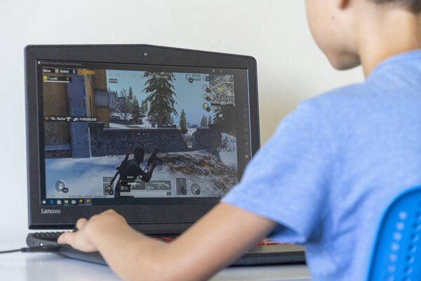 Vilnius, Lithuania - July 7, 2019: Boy playing Fortnite game on laptop computer. Fortnite is online video game developed by Epic Games