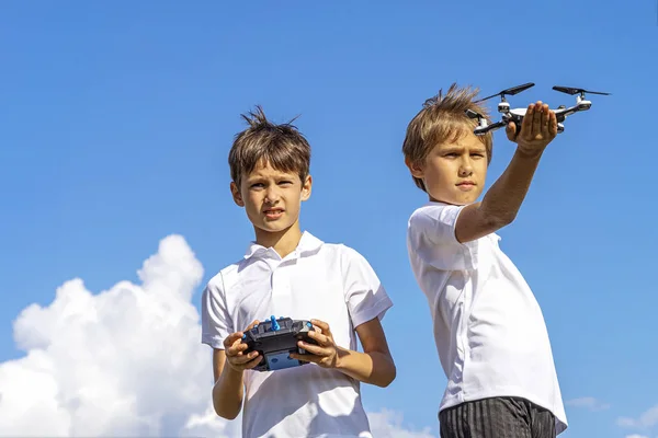 Niños jugando con dron en verano día al aire libre contra el cielo azul — Foto de Stock