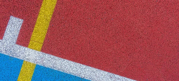 Colorful sports court background. Top view to red and blue field rubber ground with white and yellow lines outdoors