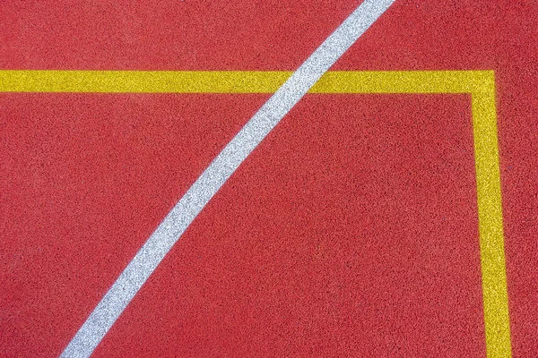 Colorful sports court background. Top view to red field rubber ground with white and yellow lines outdoors