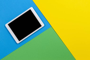 Açık mavi, yeşil ve sarı arkaplanda dijital tablet bilgisayar. Üst görünüm