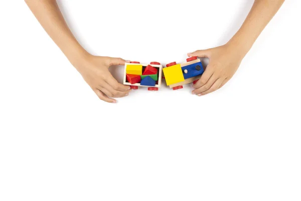 Les mains des enfants jouent avec le train de jouets sur fond de table blanche. Vue du dessus — Photo