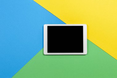 Açık mavi, yeşil ve sarı arkaplanda dijital tablet bilgisayar. Üst görünüm