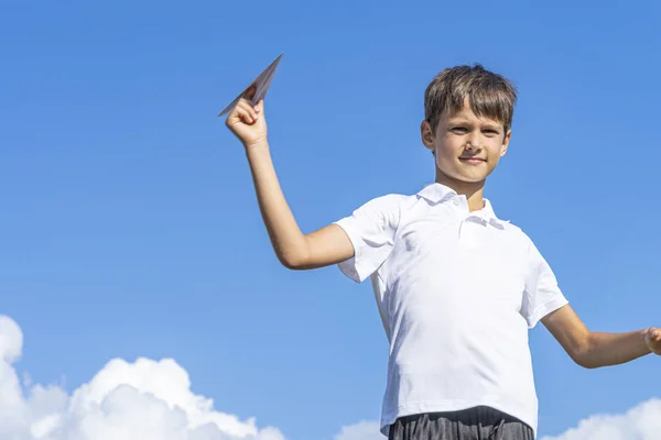 Criança feliz brincando com avião de papel contra fundo azul céu verão — Fotografia de Stock