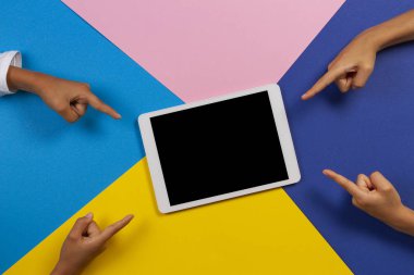 Renkli arka planda boş tablet bilgisayara parmakla işaret eden çocuklar elleri