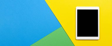 Açık mavi, yeşil ve sarı arkaplanda dijital tablet bilgisayar. Üst görünüm