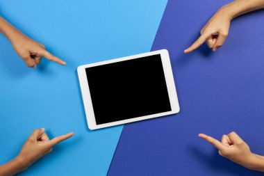 Mavi arka plandaki boş tablet bilgisayara parmak laişaret eden çocuklar