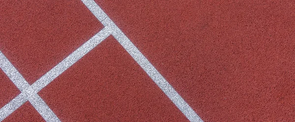 Colorful sports court background. Top view to red field rubber ground with white lines outdoors