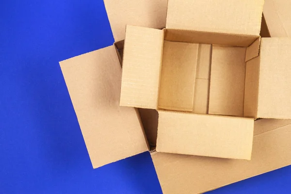 Порожні відкриті картонні коробки на синьому фоні — стокове фото